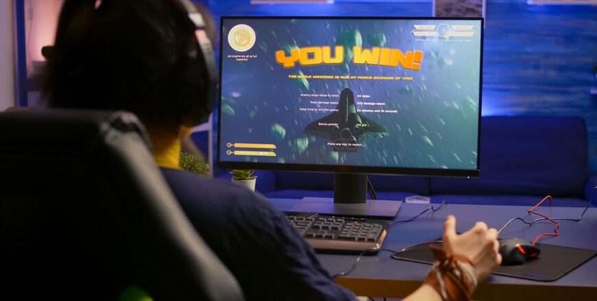 excited-pro-gamer-with-professional-headphones-making-winner-gesture-while-playing-space-shooter-video-games (1) (1).jpg